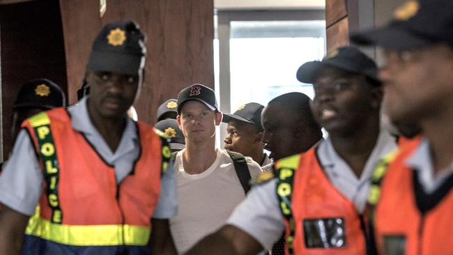 Steve Smith surrounded by security at the airport 