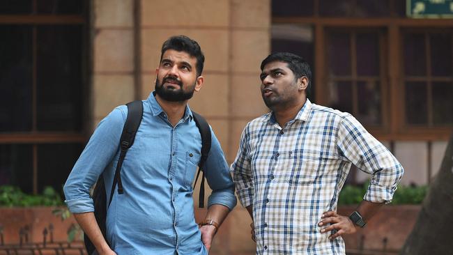 Men look at share prices displayed on a screen outside the Bombay Stock Exchange (BSE) building in Mumbai in Mumbai on January 27, 2023 on Friday, when Adani performed the worst out of all companies. Picture: Sujit Jaiswal/AFP