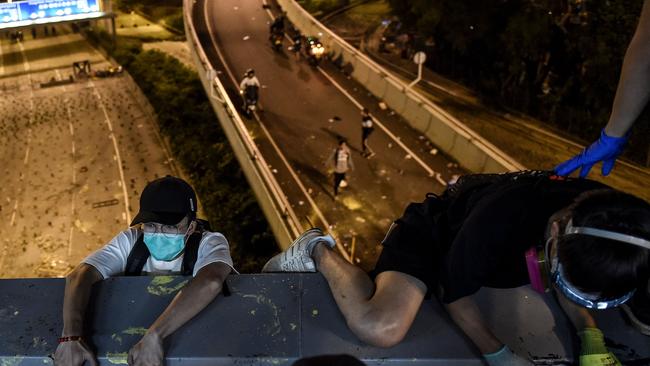 Protesters use ropes from a bridge down to a highway to escape from Hong Kong Polytechnic University campus and from police. Picture: AFP