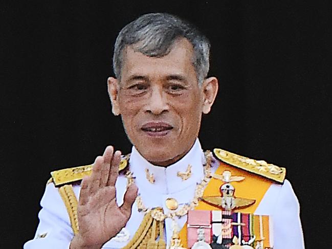 (FILES) In this file photo taken on May 6, 2019, Thailand's King Maha Vajiralongkorn waves from the balcony of Suddhaisavarya Prasad Hall of the Grand Palace during a public audience on the final day of his royal coronation in Bangkok. - Thailand's King Maha Vajiralongkorn has stripped his 34-year-old consort of all titles, the palace announced October 21, a shock move less than three months after she was bestowed with a position that had not been used for nearly a century. (Photo by Jewel SAMAD / AFP)