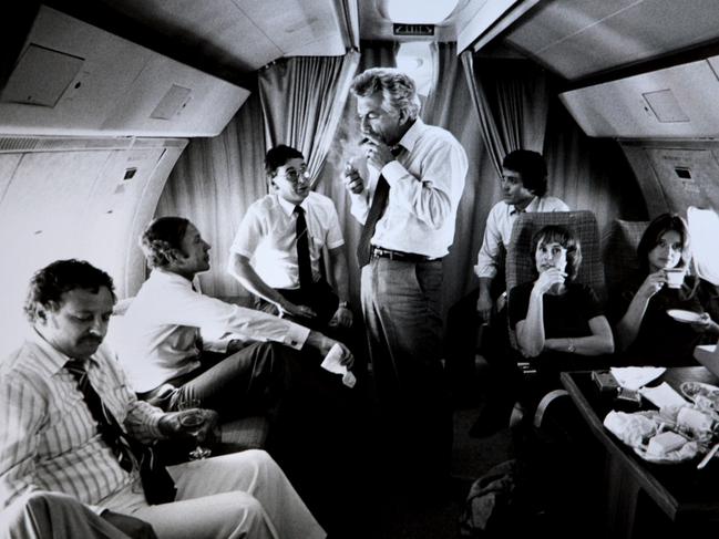 New Labor and Oppostion leader Bob Hawke surrounded by advisors and media (L-R) journalist Colin Parks, Senator Kerry Sibraa, journalist Peter Logue, senior advisor Geoff Walsh, staffers Kate Moore and Janet Willis, lights up a cigar on a VIP flight during the 1983 Federal Election Campaign, which saw Labor swept to a landslide victory. Picture: Ray Strange