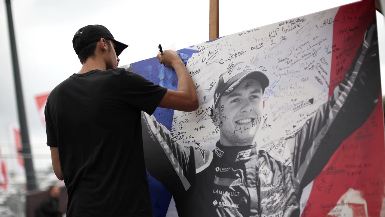 A man signs a remembrance board for Formula 2 driver Anthoine Hubert.