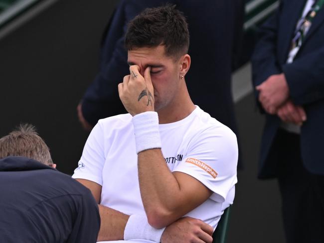 LONDON, ENGLAND - JULY 04: Thanasi Kokkinakis of Australia receives medical treatment before retiring injured during in his Gentlemen's Singles second round match against Lucas Pouille of France during day four of The Championships Wimbledon 2024 at All England Lawn Tennis and Croquet Club on July 04, 2024 in London, England. (Photo by Mike Hewitt/Getty Images)