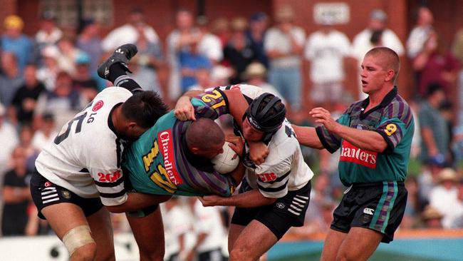 Brendan Hurst is tackled by Western Suburbs players.