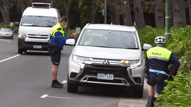 Police check a driver’s details. Picture: William West/AFP