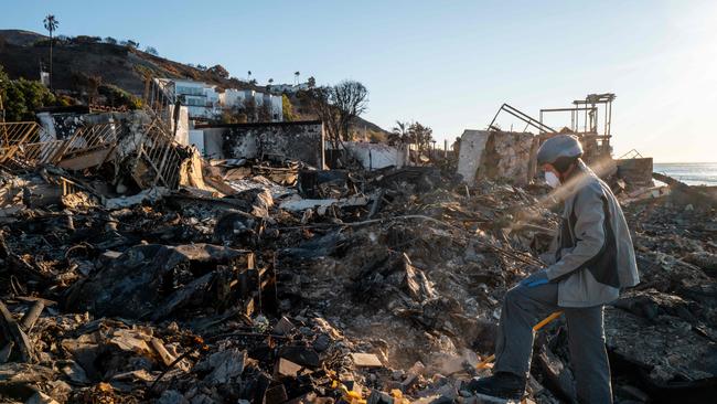 MALIBU, CALIFORNIA - JANUARY 13: Patrick O'Neal sifts through his home after it was destroyed by the Palisades wildfire on January 13, 2025 in Malibu, California. "I'm trying to figure out where I am in the house... I think i'm standing in my dad's bathroom. To be honest, I don't even know what I'm looking for I guess I'm just trying to make sense of it. There's nothing left, just ash and bricks-there's nothing," said O'Neal. Multiple wildfires fueled by intense Santa Ana Winds are burning across Los Angeles County. Reportedly at least 25 people have died with over 180,000 people under evacuation orders. Over 12,000 structures have been destroyed or damaged, while more than 35,000 acres have burned.   Brandon Bell/Getty Images/AFP (Photo by Brandon Bell / GETTY IMAGES NORTH AMERICA / Getty Images via AFP)