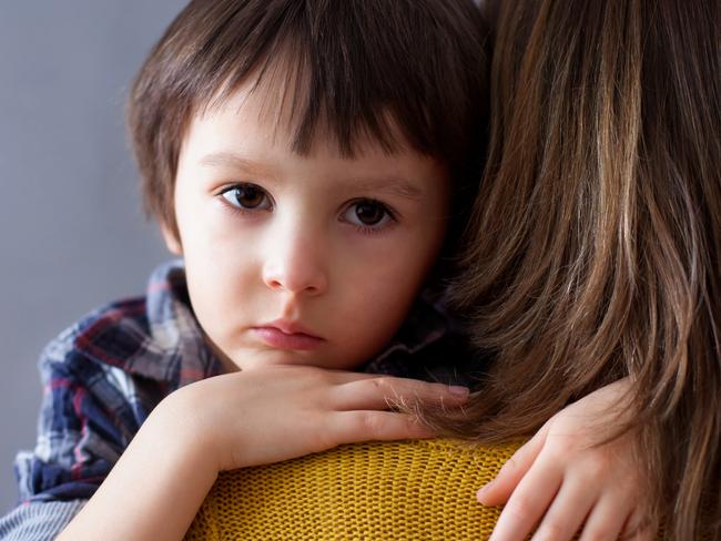 Sad little child, boy, hugging his mother at home, isolated image, copy space. Family concept