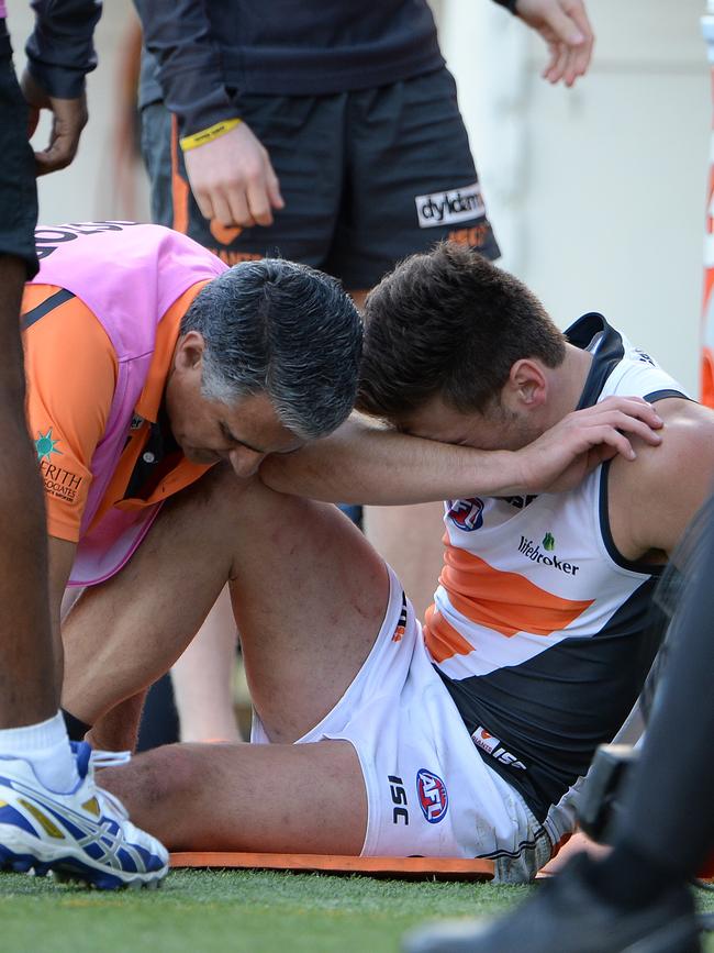 A trainer attends to a groggy Stephen Coniglio.