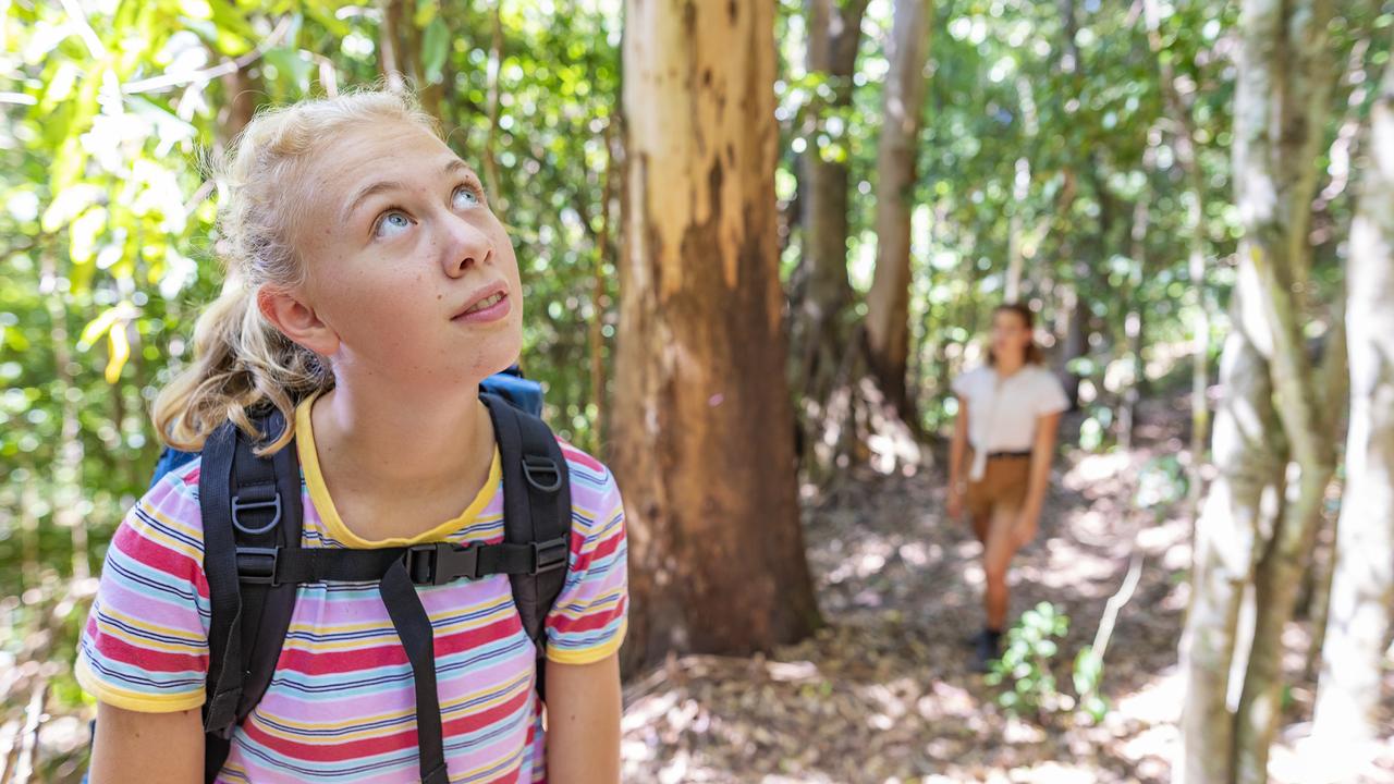 Teenage girls hiking with a backpack in the Australian wilderness during a hot summer