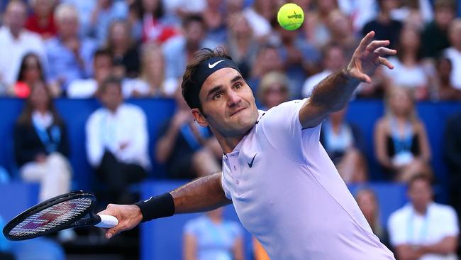 Roger Federer of Switzerland smashes the ball into the air after missing a shot during his singles finals match against Alexander Zverev.