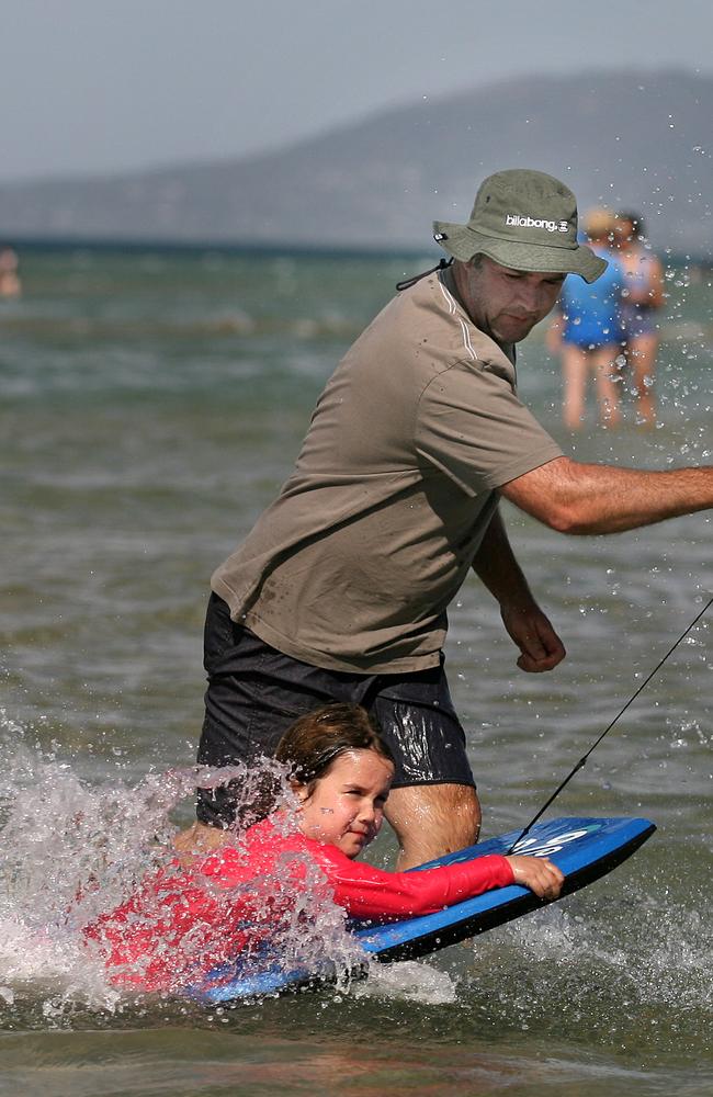 Dean and his daughter Isobel, 5, cooling off at Rye for New Year’s Eve 2010. Picture: Chris Scott