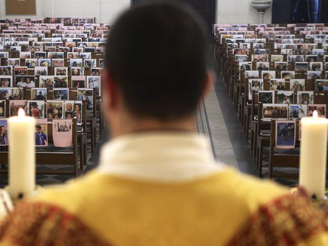 Catholic priest father Georges Nicoli celebrates a Holy Thursday mass, livestreamed on Facebook, with pictures of parishioners taped to the benches in the empty Notre Dame De Lourdes church in Bastia, on the French Mediterranean island of Corsica on April 9, 2020, on 24th day of a lockdown in France aimed at curbing the spread of the COVID-19 pandemic, caused by the novel coronavirus. (Photo by Pascal POCHARD-CASABIANCA / AFP)