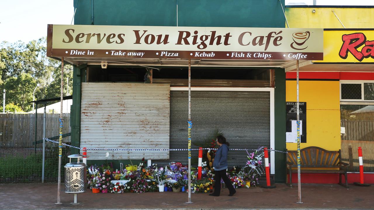 The Serves You Right Cafe in Ravenshoe after a gas explosion destroyed it, leaving 18 injured and Nicole Dempsey and Margaret Clark dead. A woman walks past the floral tributes laid at the front of the cafe. PICTURE: BRENDAN RADKE