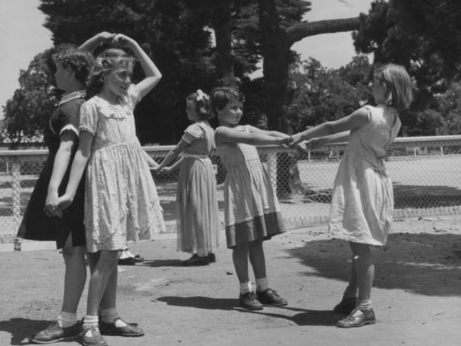 With no TVs or iPads in 1954, kids had to make their own fun. These girls are playing Wash the Dishes in a Melbourne park in 1954. Picture: Museum Victoria.