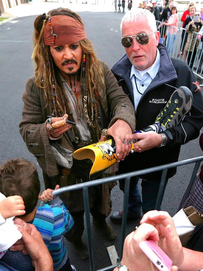 Johnny Depp signs a fans prosthetic leg at Cleveland. Picture: Peter Wallis
