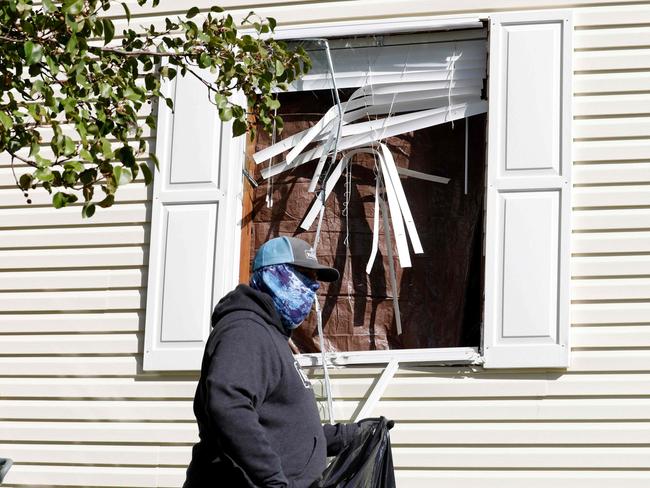 A person cleans up debris from a broken window at a home FBI agents searched. Picture: AFP