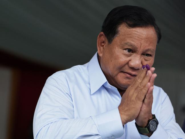 Indonesia's presidential candidate Prabowo Subianto gestures after staining his fingers with ink at a polling station after he voted in Indonesiaâs presidential and legislative elections in Bogor, West Java on February 14, 2024. Voting began on February 14 in Indonesia's presidential, national and provincial elections at more than 800,000 polling stations across the country, with nearly 205 million people eligible to cast their ballot. (Photo by Yasuyoshi CHIBA / AFP)