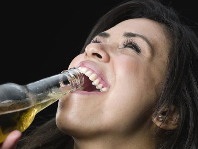 Hispanic young woman drinking beer