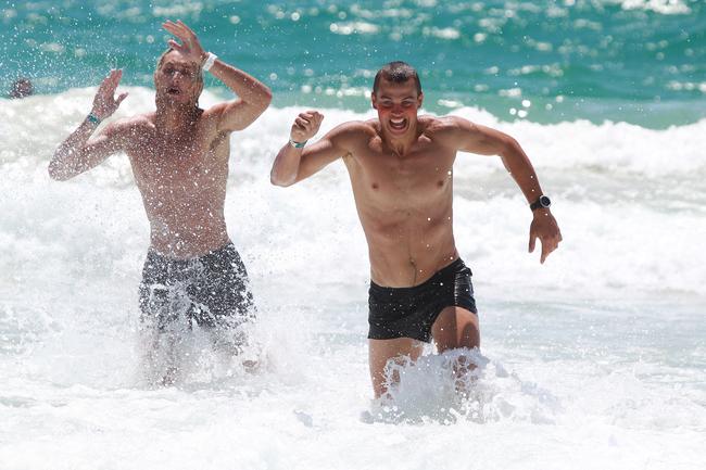 Ryan Gilmore (right) runs out of the water during the Southport Sharks VFL team preseason training camp at Tallebudgera Beach. Ryan Gillmore. Picture: Mike Batterham.