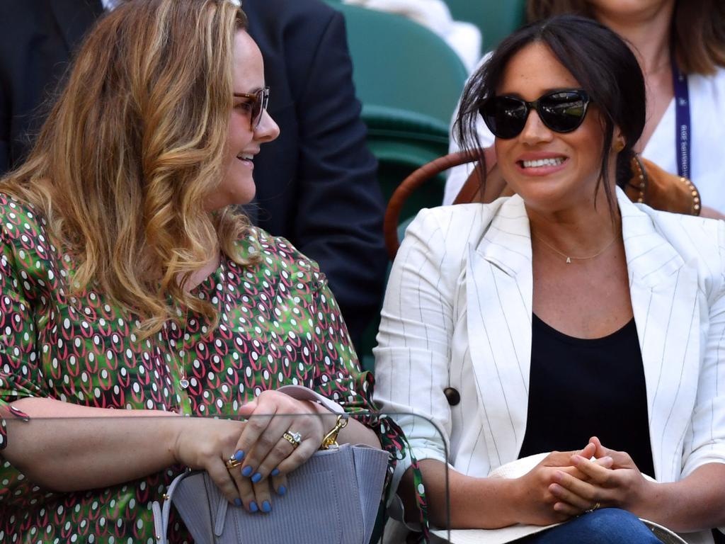 Meghan chats to a friend while watching the action on centre court. Picture: AFP