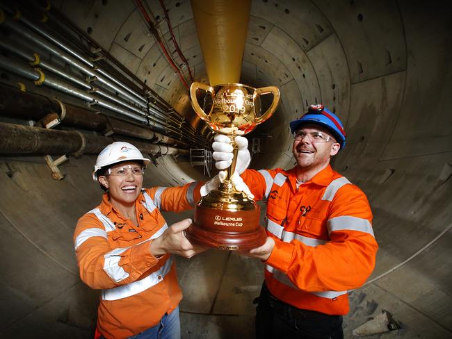 The Melbourne Cup finds its way down into part of the Metro Tunnel project in North Melbourne. Workers Kat Thomas and Tim Wilson hold the Cup in one of the freshly dug tunnels. Picture: David Caird