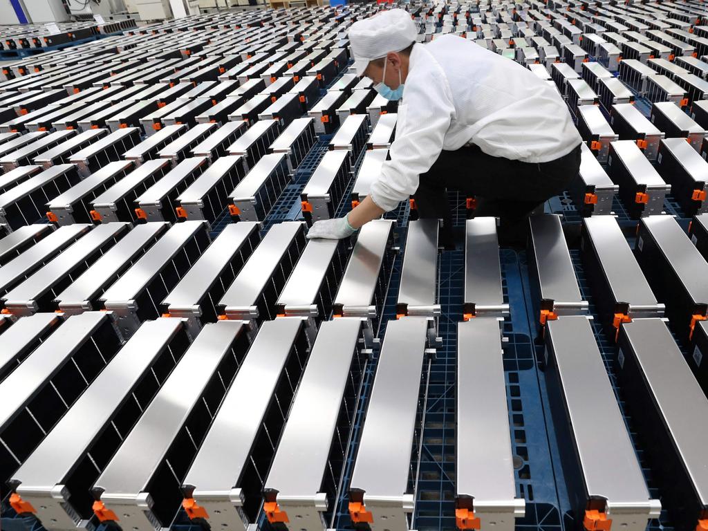 A worker with car batteries at a factory for Xinwangda Electric Vehicle Battery Co. Ltd, which makes lithium batteries for electric cars and other uses. Picture: AFP