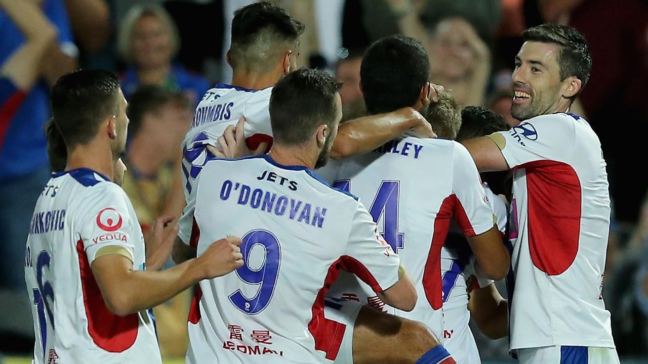 Newcastle Jets players celebrate their eighth and final goal against the Mariners on Saturday night.