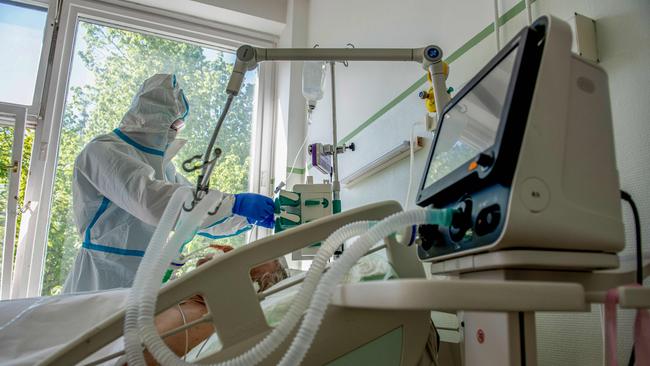 A doctor wearing personal protective equipment (PPE) as he treats a Covid-19 patient on a ventilator. Picture: Karoly Arvai / AFP.