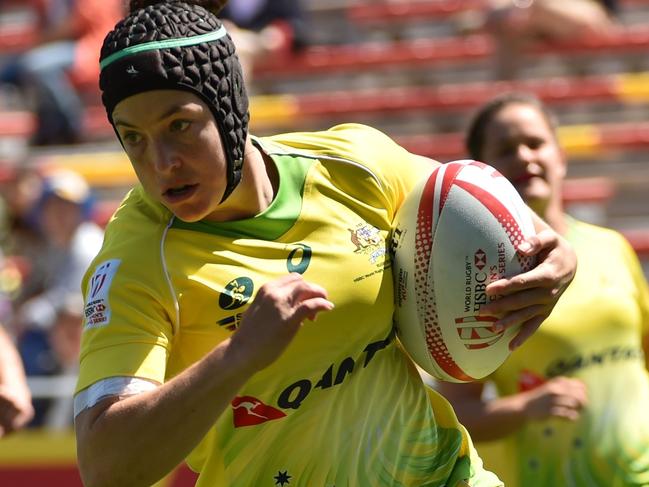 Australia's Emilee Cherry (C) runs with the ball against France during their quarter-final match at the World Rugby Women's Seven Series in Kitakyushu, Fukuoka prefecture on April 23, 2017. / AFP PHOTO / Kazuhiro NOGI