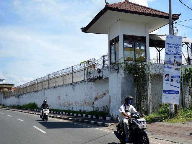 This picture taken on November 3, 2020 shows motorists pass by Bali's Kerobokan prison where hundreds of prisoners have fallen ill with Covid-19 and dozens of inmates at other prisons are believed to have died, underscoring fears that the virus would run rampant through Indonesia's notoriously overcrowded corrections system, according to prisoner accounts and rights groups. (Photo by Sonny Tumbelaka / AFP)