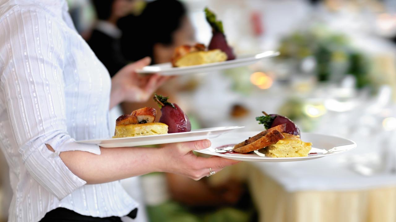 Waitress carrying three plates with meat dish Generic photo of woman working in hospitality industry