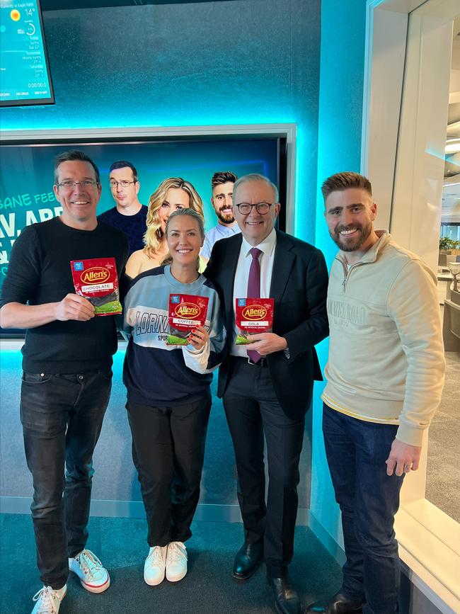 Stav Davidson, Abby Coleman, Prime Minister Anthony Albanese and Matt Acton from Brisbane's B105 radio morning show with three sample packets of the new brown snake lolly they campaigned for, designed as a tribute to the Brisbane river. Picture: Supplied