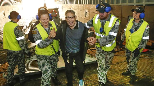 Evacuees being welcomed aboard HMAS Choules on Friday. Picture: David Caird