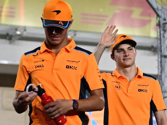 McLaren's British driver Lando Norris (L) and McLaren's Australian driver Oscar Piastri (R) wave to the fans ahead of the Qatari Formula One Grand Prix at Lusail International Circuit on October 8, 2023. (Photo by Ben Stansall / AFP)