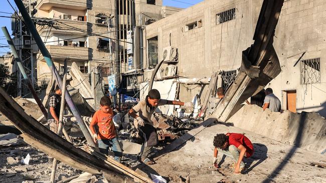 Boys inspect the rubble of a collapsed building in the aftermath of Israeli bombardment at the Jaouni school run by the UN Relief and Works Agency for Palestine Refugees (UNRWA) in Nuseirat in the central Gaza Strip on July 6. Picture: AFP