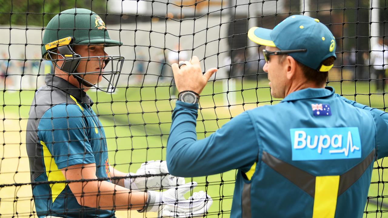 Marcus Harris of Australia chats with coach Justin Langer.