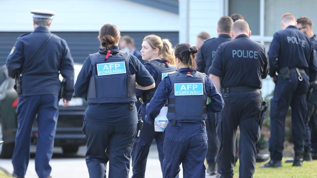 Australian Federal Police officers, including a forensic team, assemble at the Toongabbie house yesterday. Picture: John Grainger