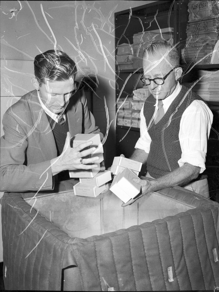 Doses of Salk vaccine are being unpacked at Commonwealth Health Department serum section after being flown from Melbourne. L. Dempsey, left, officer in charge, and P Duffy were transferring the vaccine to a storage refrigerator. Picture: Bob Millar Snr