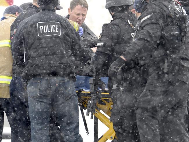 Officer down ... Emergency personnel transport an injured police officer near the clinic. Picture: Andy Cross/The Denver Post.