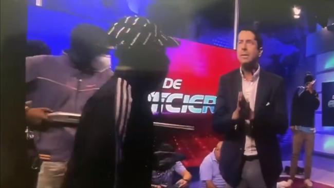 A group of armed men broke into a live television studio in Ecuador and threatened staff, footage shows. Picture: TC