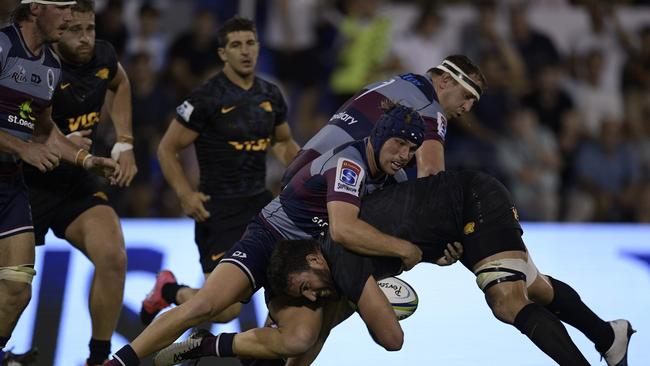 Argentina's Jaguares lock Lucas Paulos, right, is tackled by Australia's Reds centre Hamish Stewart, centre, and prop JP Smith, centre back.