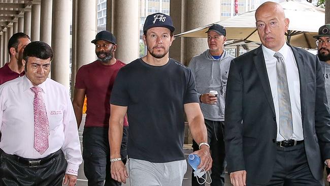 Hollywood star Mark Wahlberg (centre) signs a $50 million deal with United Cinemas owner Roy Mustaca (left) to bring his chain of Wahlburgers restaurants to Australia. Picture: Chris Khoury