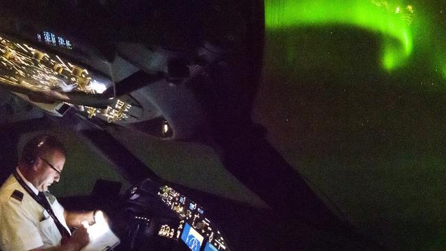 Captain Alex Passerini on the flight deck, with the lights in the background.