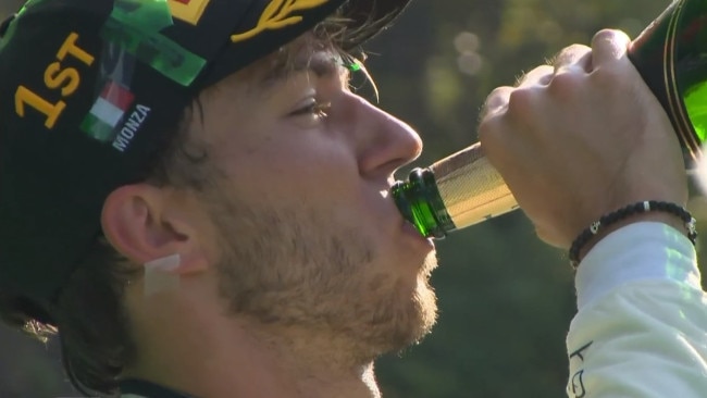 Pierre Gasly celebrates with a giant swig of champagne.