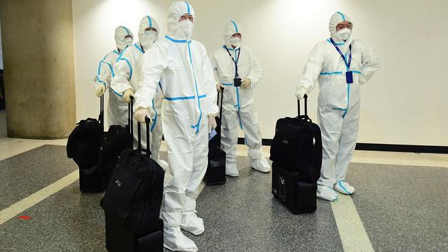 Flight crew from Air China arrive in hazmat suits in the international terminal at Los Angeles International Airport.