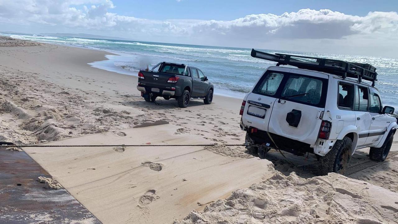 Two 4WDs were pulled out of the water at Teewah Beach after being swamped on the weekend. Pictures: Clayton's Towing