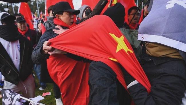 China supporters appear to cover protester with Chinese flag. Picture: DrewPavlou