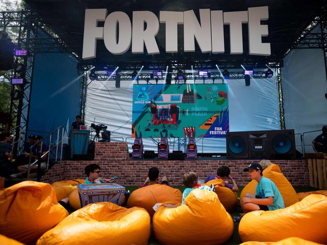 (FILES) In this file photo boys sit on pillows outside during the 2019 Fortnite World Cup Finals - Round Two on July 27, 2019, at Arthur Ashe Stadium, in New York City. - The maker of video game sensation "Fortnite" on August 13, 2020 sued Apple for the way it rules over the App Store, accusing the iPhone maker of wielding monopoly power. Epic Games called on a federal judge to order Apple to stop its "anti-competitive conduct" and invalidate the tech giant's rules requiring app developers to pay 30 percent of transactions as the price of doing business in the App Store. (Photo by Johannes EISELE / AFP)