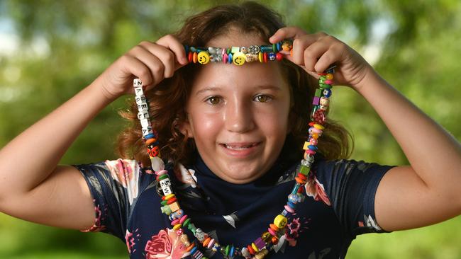 Townsville couple Brett and Peta Hearn with twins Bethany and Izabella, 11, have a special reason to support Sweetheart's Day this Valentine's Day with Izabella diagnosed while still in the womb with congenital heart disease. Izabella with some of her beads for different medical procedures. Picture: Evan Morgan