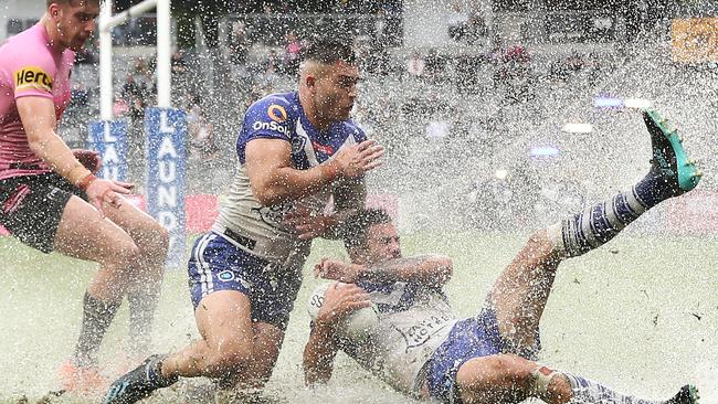 Nick Cotric and Corey Allan slide in to win possession in the wet.